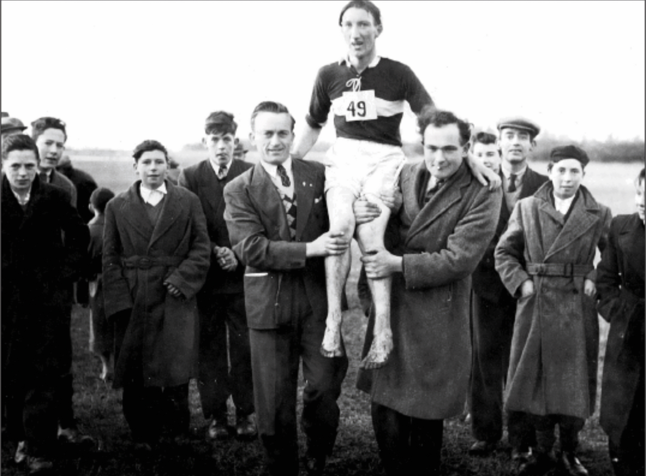 Tommy Madden of Derrydonnell A.C., pictured with local supporters following his victory in the County Cross-Country Championships in 1954 in the grounds of Liam Mellowes College, known then as the Farmyard. Carrying Tommy are Dinny Sullivan (Club Secretary) and John Joe Ruane. Also in the picture are Michael Freaney, Tomsie Cannon, Frank Rabbitte, Ned Qualter and Michael Madden. 